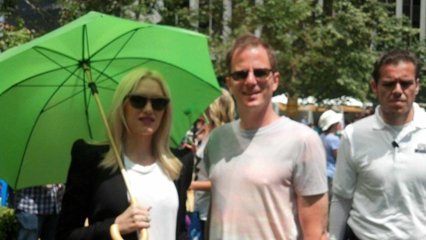 David DuVal with Gwen Stefani under a bright green umbrella at an outdoor event